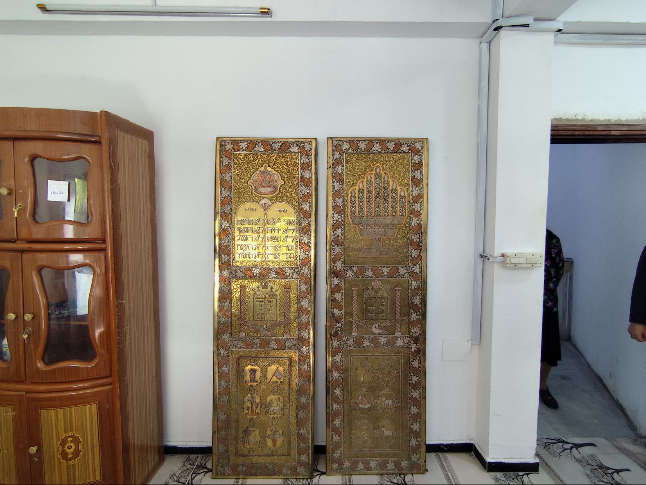 Close-up of recovered golden synagogue panels with Hamsa symbol, Tablets of the Law, and Hebrew inscriptions